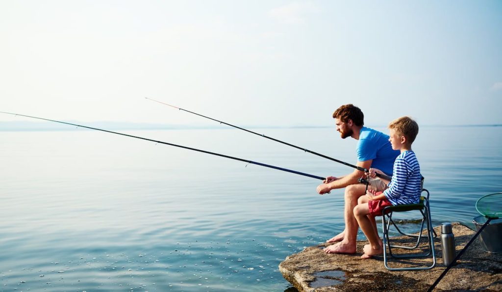 man and little boy fishing together