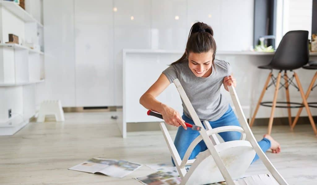 Woman  at home painting a chair