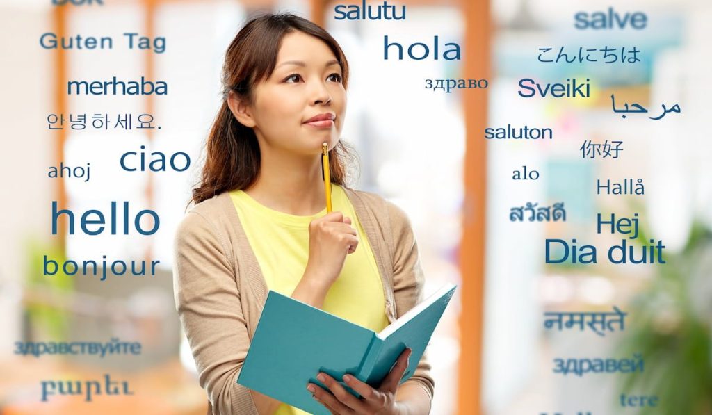 woman with diary and pencil thinking over greeting words in different foreign languages