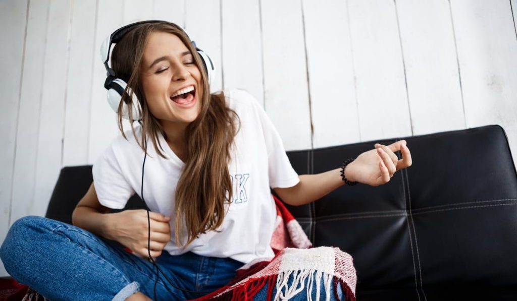 Girl in plaid listening music in headphones