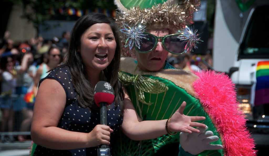 parade participant newsbombs the TV reporter during the parade