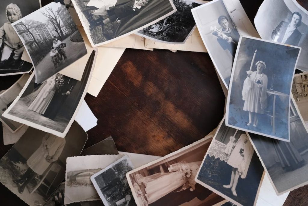 old photographs on old wooden table, concept of genealogy