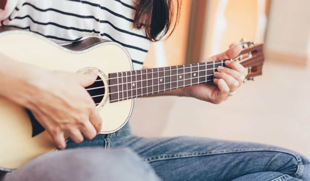 Woman play a song on ukulele