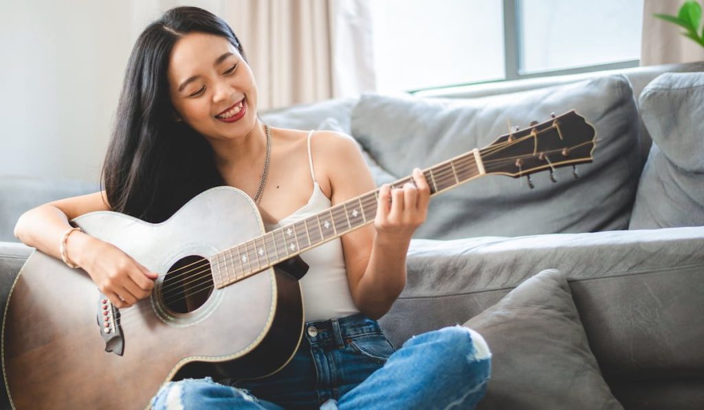 a woman playing acoustic guitar