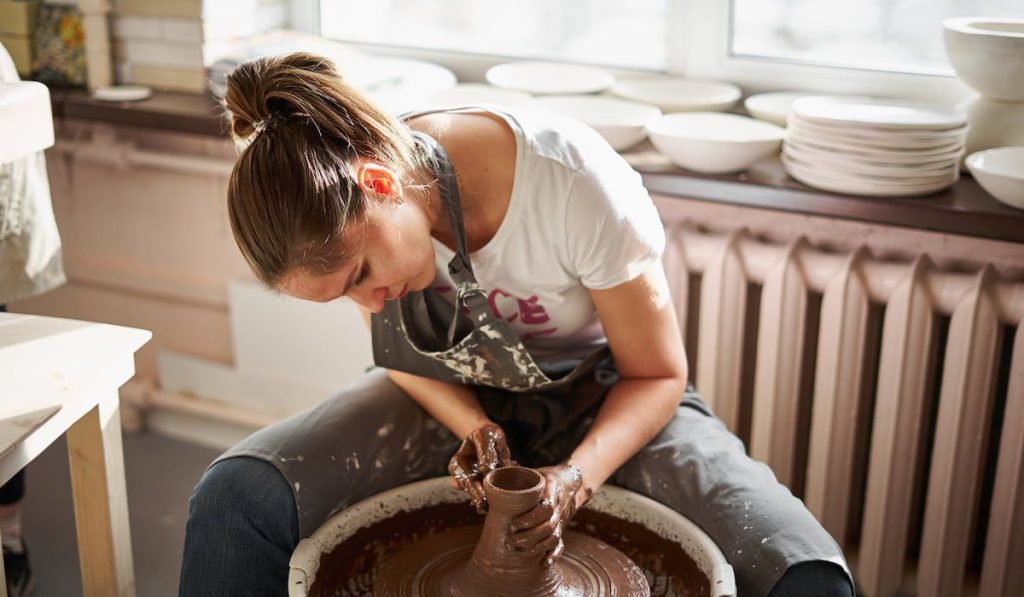 woman making ceramic pottery on wheel