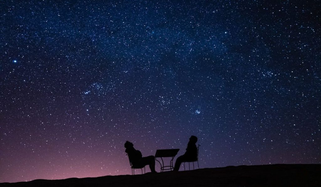 couple observing the stars and the milky way above them
