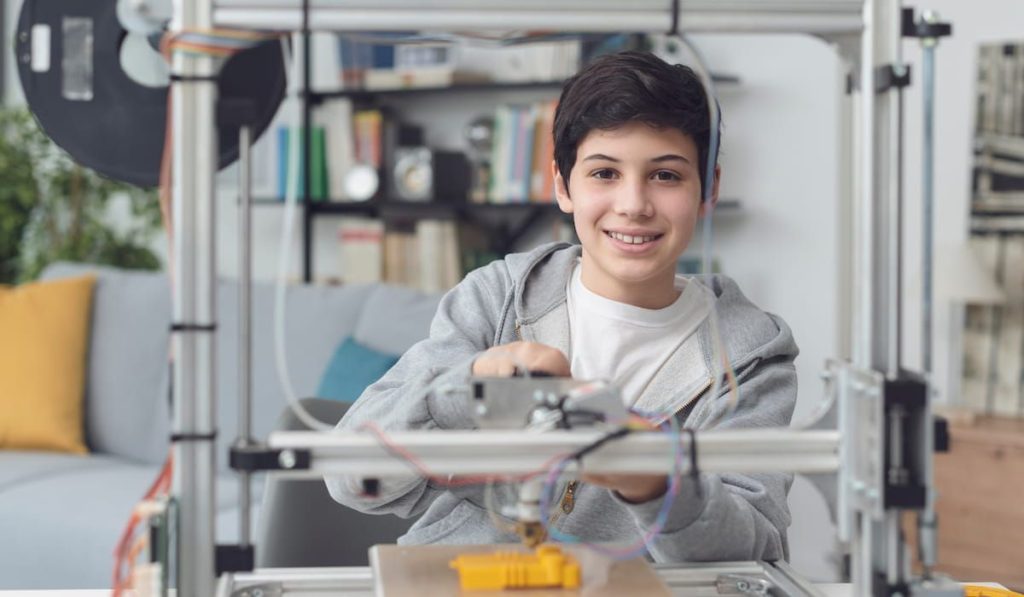 young boy learning how to use a 3D printer 