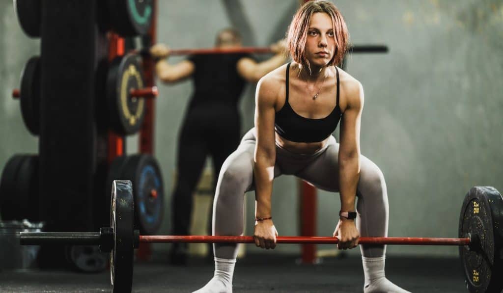 Muscular woman weightlifting in gym