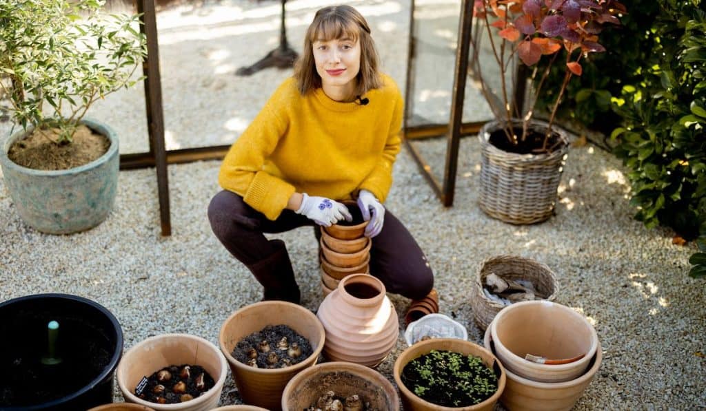 Woman planting flowers in pots at the garden
