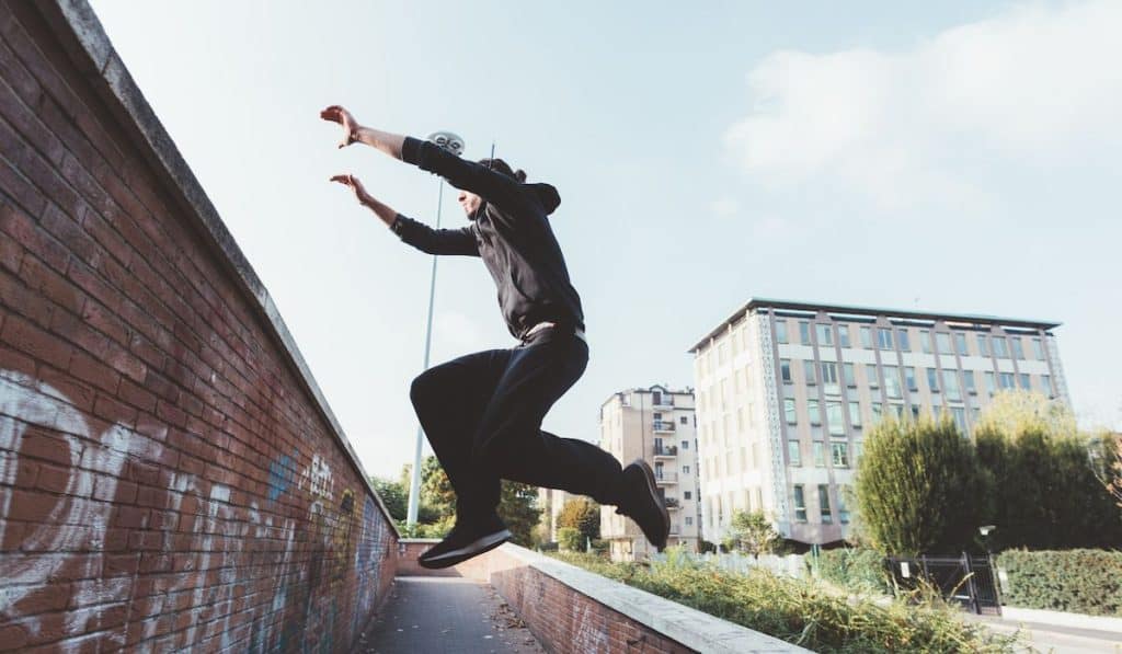 Young man doing parkour outdoor in the city in autumn, stunt, trick concept