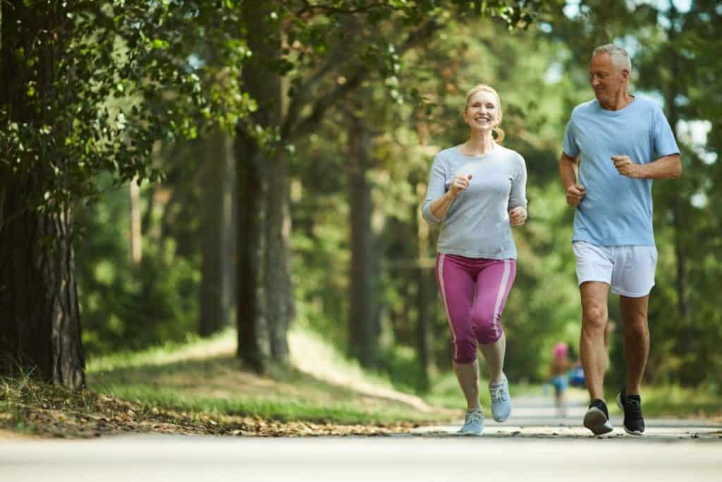 middle aged couple running at the park