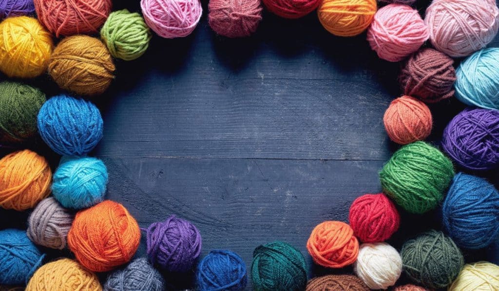 Colorful balls of wool on wooden table