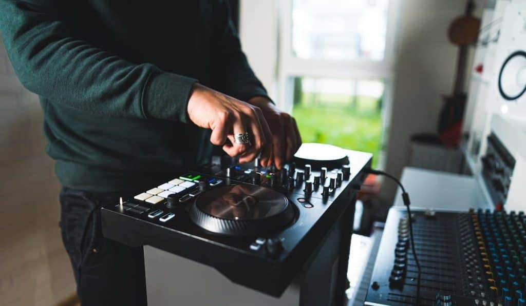 Hands of a man playing on DJ setup at home 
