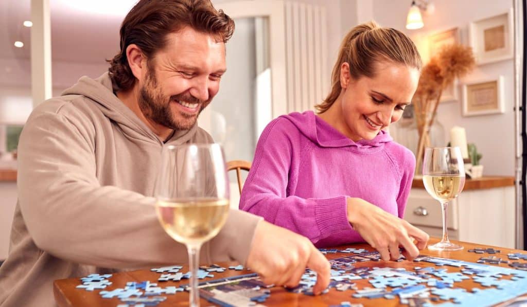 happy couple playing puzzle on a wine date night
