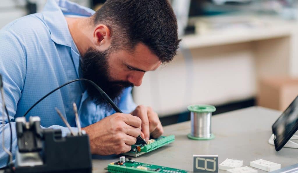 Electronics engineer working in a workshop with tin soldering parts