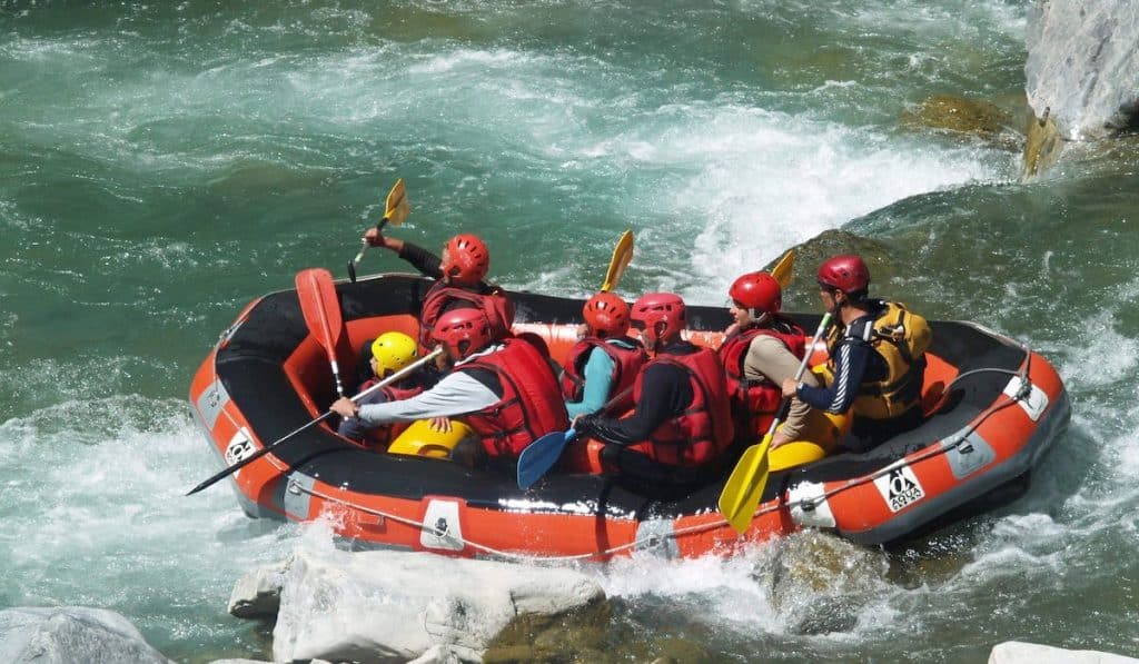 Group of friends enjoying whitewater rafting outdoor activities