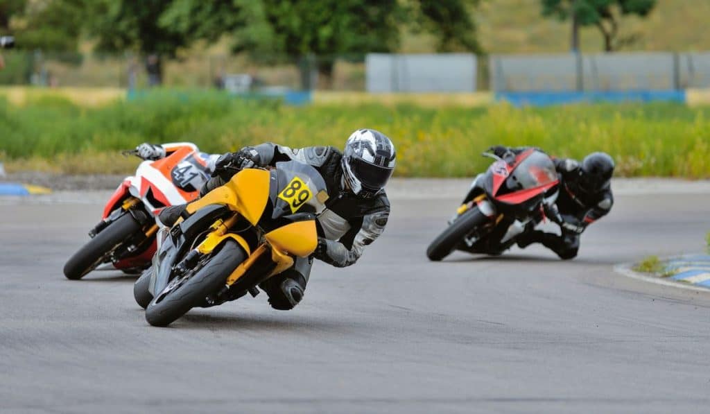 Motorcycle racing leaning into a fast corner on track