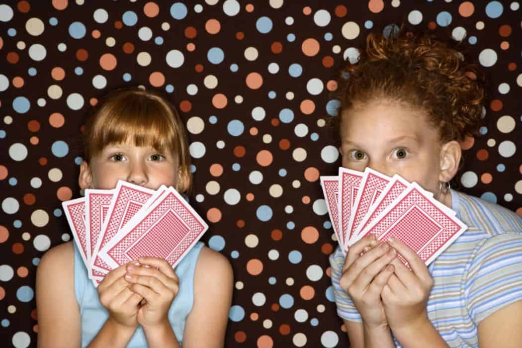 Two girls hold deck of cards