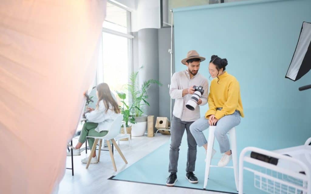 a photographer showing photos to the model in the studio