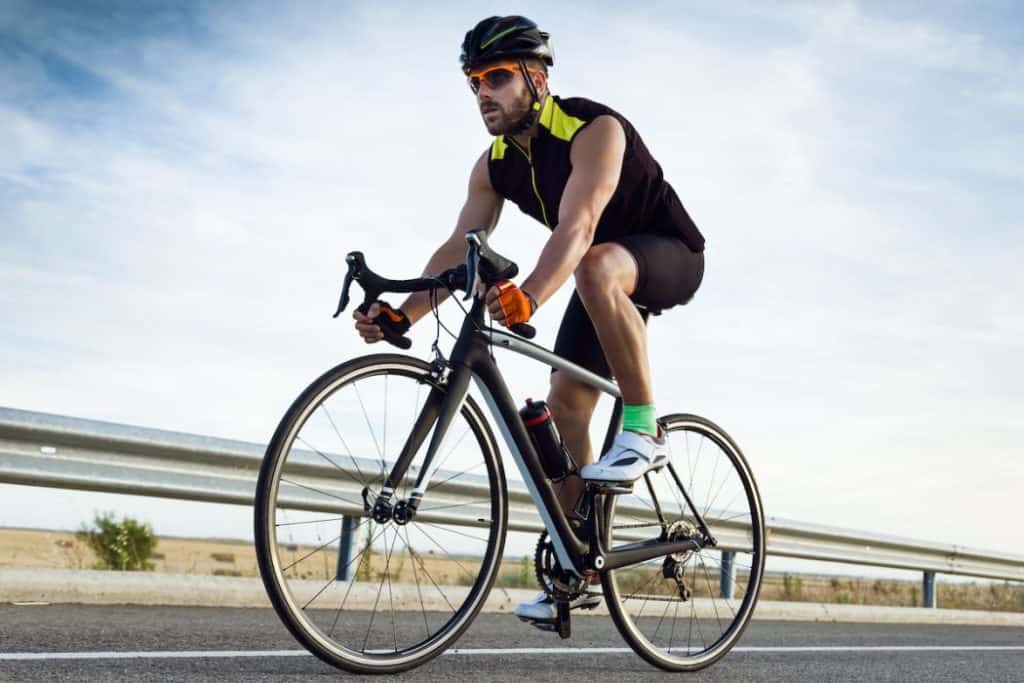 a young man cycling at the side of the road 