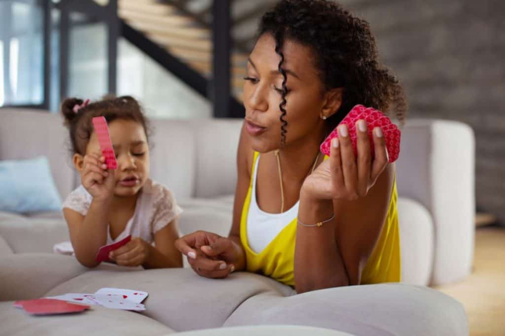 mother and daughter playing cards in the living room