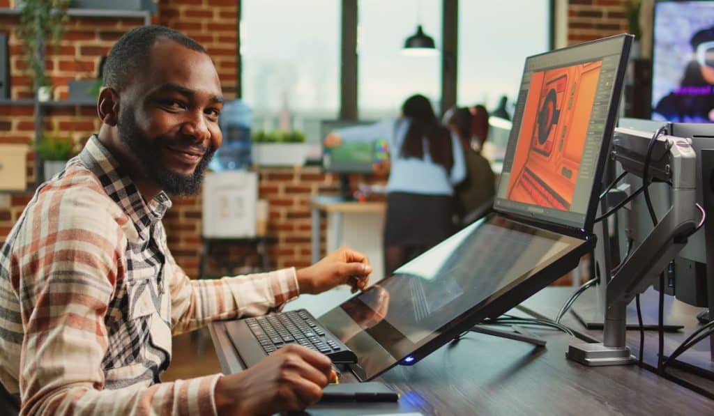 office worker sitting at computer and creating digital art
