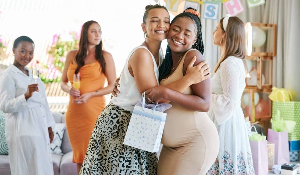 pregnant mother receiving gifts from her friends at her baby shower