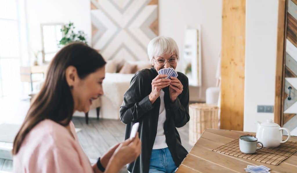 Cheerful diverse women enjoying card game laughing
