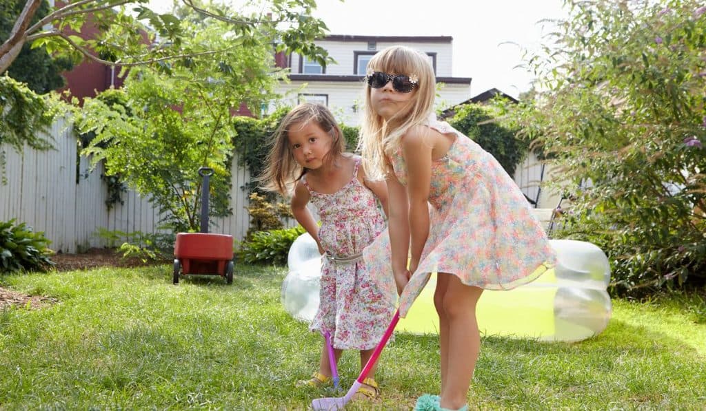 Girls playing kids golf in garden
