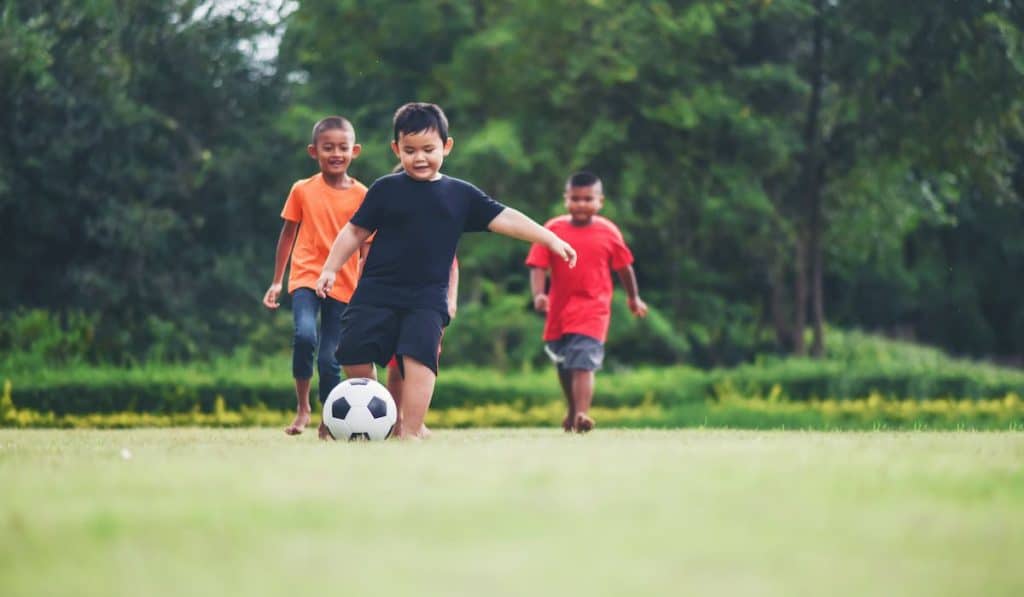 Kids playing soccer football in the park