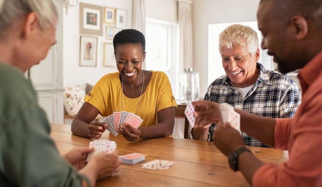 Mature friends playing cards at home
