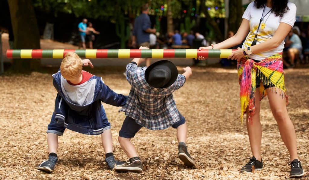 Shot of two kids doing the limbo at an outdoor festival 