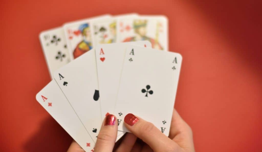 Woman’s hand holding four aces

