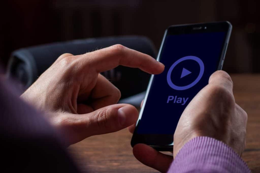 a man about to play music on his phone using his finger 