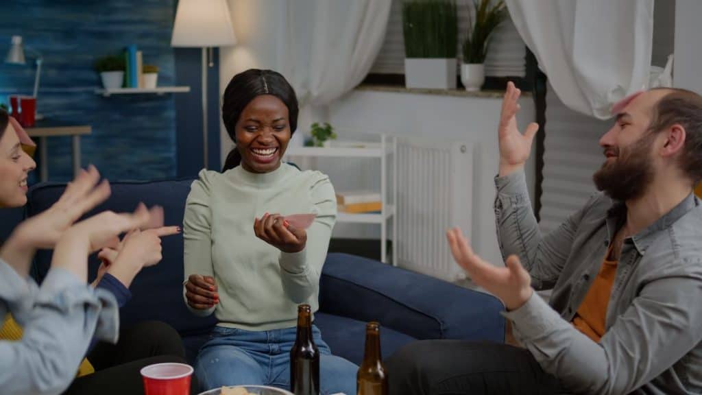 friends playing Guess Who game while drinking 