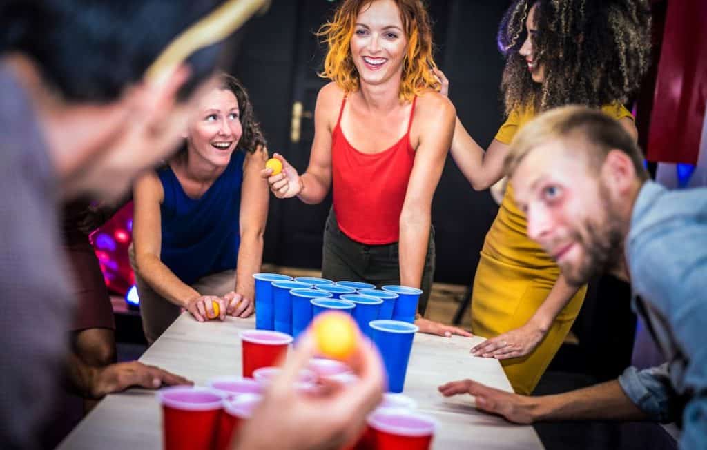 girl in red will take a shot on beer pong in a party
