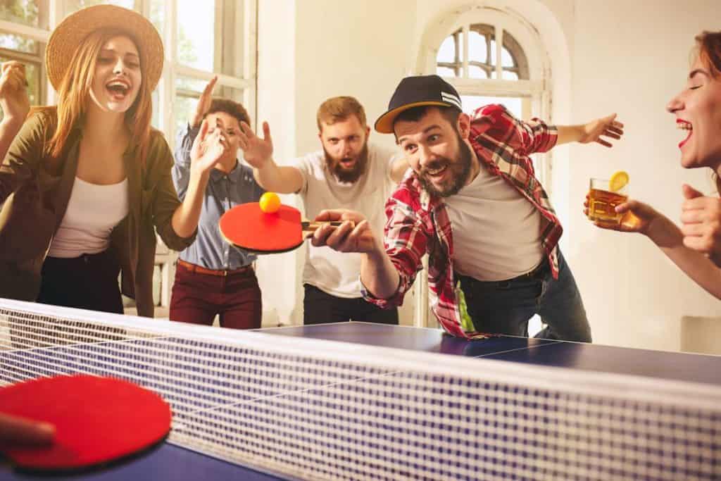 group of young people playing ping pong match during a party