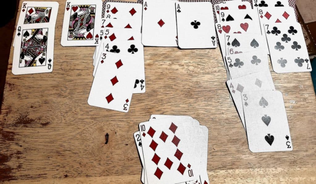 playing solitaire card game on wooden table