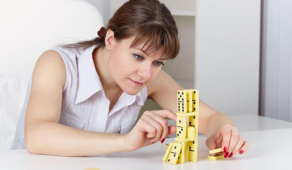 young beautiful woman plays with dominoes