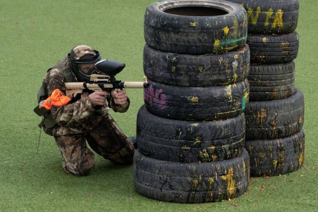 People in camouflage, with paintball guns and masks