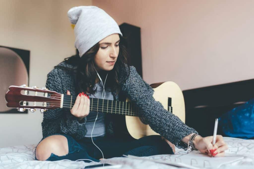 A young woman composing a new song in her bedroom