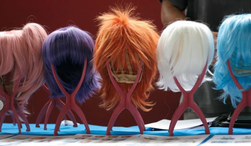 wigs on display for sale on a table at a cosplay event
