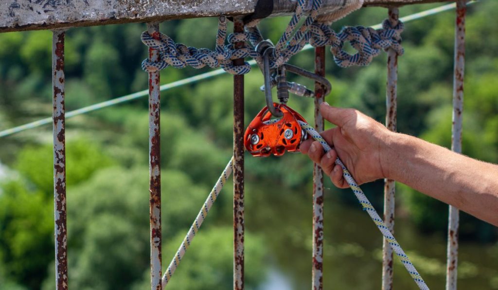 A man is making ropes and lifting gear ready for doing rope jumping from the bridge