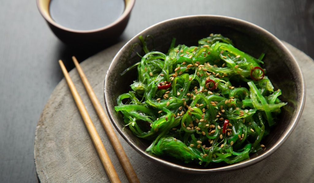 Wakame seaweed salad with sesame seeds and chili pepper in a bowl