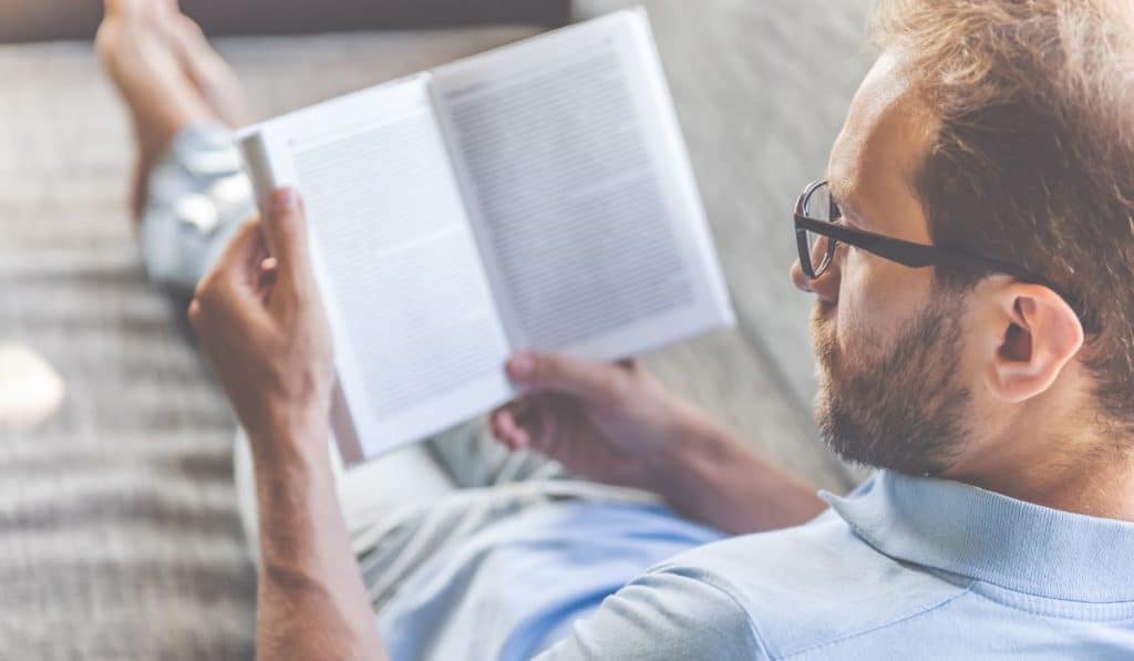  businessman in casual clothes and eyeglasses reading a book