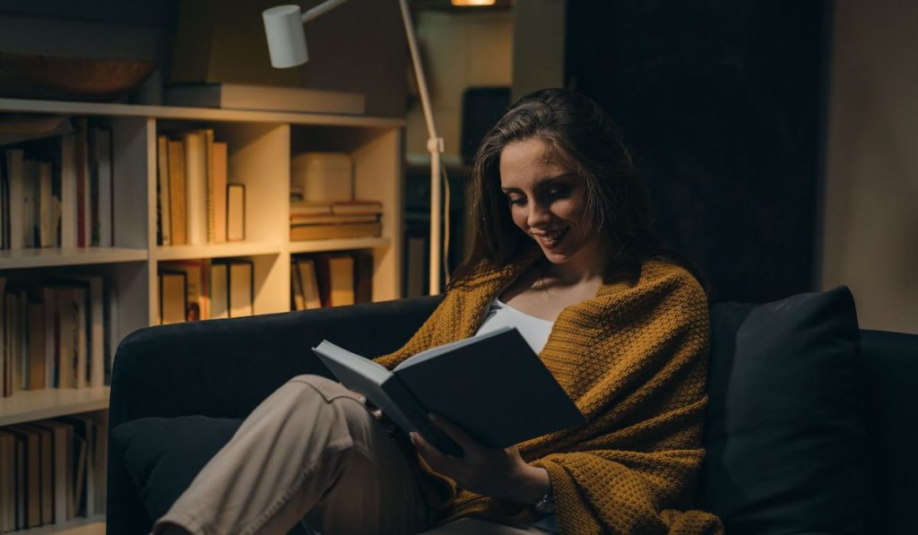 woman relaxing on sofa and reading book