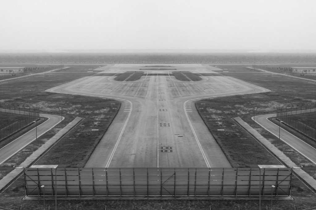 An empty airport runway with a jet blast deflector