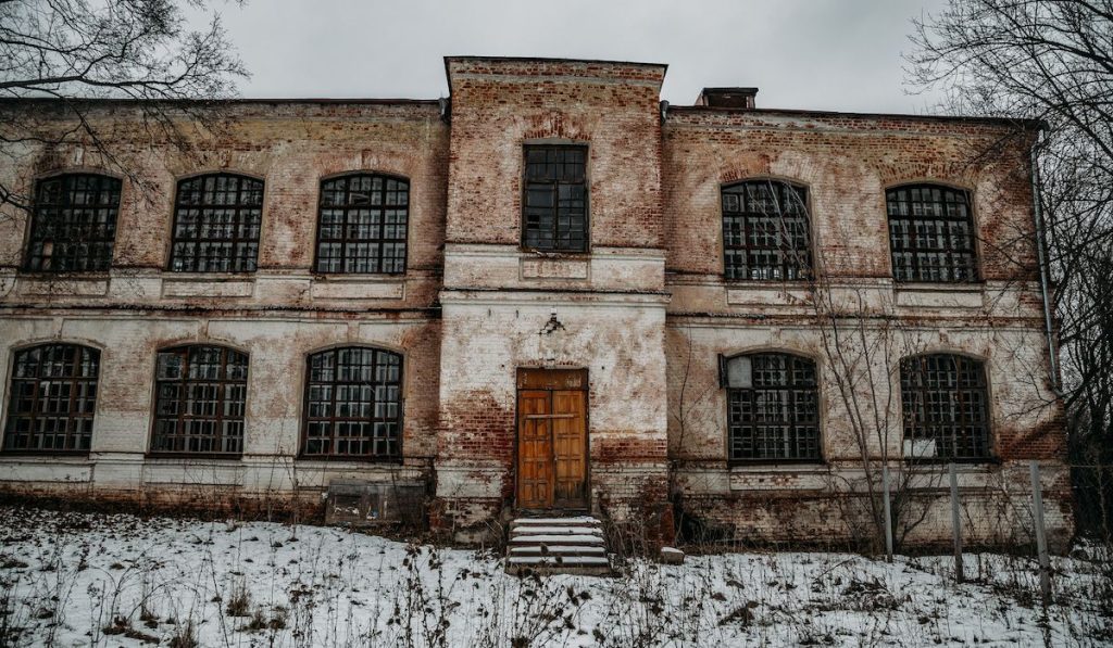 Dark and creepy abandoned haunted mental hospital in winter
