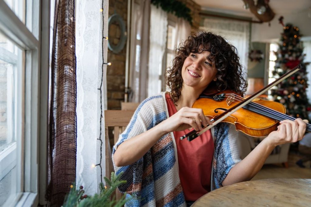 young woman musician plays the violin practicing musical instrument
